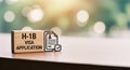 This image represents the H1B Visa application process. Features a wooden block with the text H1B VISA APPLICATION and document Royalty Free Stock Photo