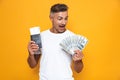 Image of rich man 30s in white t-shirt holding money fan and travel tickets Royalty Free Stock Photo