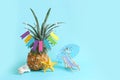 Image with ripe pineapple with parasol and beach chair over blue background. Summer holidays and tropical theme Royalty Free Stock Photo
