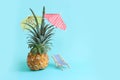 ripe pineapple with parasol and beach chair over blue background. Summer holidays and tropical theme Royalty Free Stock Photo