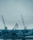Image of river, floating cranes, buildings on river bank. Royalty Free Stock Photo