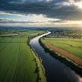 River Shannon flows between green grass fields and agriculture land. Irish landscape. Low cloudy sky. Aerial