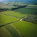 River Shannon flows between green grass fields and agriculture land. Irish landscape. Low cloudy sky. Aerial