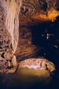 Rock formations in dark cave with underground waterfall Royalty Free Stock Photo