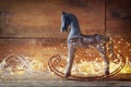 Image of rocking horse and magic christmas lights on wooden table Royalty Free Stock Photo