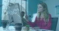Image of rotating globe and computer language over caucasian woman analyzing reports