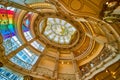 Rotunda glass ceiling dome with balcony on right and windows leading to rainbow LGBTQ flag on left