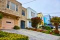 Row of houses side by side with fun and colorful landscaping between driveways and fancy entrance