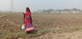 It is an image of a rural woman of India who is stayed in field.