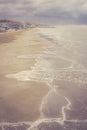 Image of the sand coast with dramatic sky and rolling waves