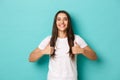 Image of satisfied smiling brunette girl, wearing white t-shirt, showing thumbs-up in approval, like and recommend Royalty Free Stock Photo