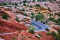 Scenic road curving tightly through red sand desert and large rocks