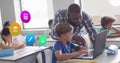 Image of school icons over african americ male teacher and schoolboy using laptop in class