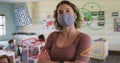 Image of school items icons moving over female teacher wearing face mask