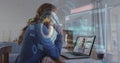 Image of scope scanning and data processing over woman using laptop on image call Royalty Free Stock Photo