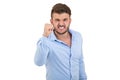 Image of screaming angry young bearded emotional man standing over white wall background isolated.