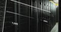 Image of screens with programming language and numbers moving over data server racks Royalty Free Stock Photo