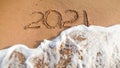 Image of sea wave washing out 2021 numbers written on wet sand at beach. Concept of New Year, Christmas and travel on Royalty Free Stock Photo