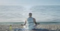 Image of seascape over a meditating african american man