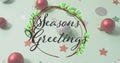 Image of seasons greetings text over christmas decorations Royalty Free Stock Photo