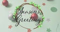 Image of seasons greetings text over christmas decorations Royalty Free Stock Photo