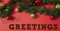Image of seasons greetings text over christmas decorations Royalty Free Stock Photo