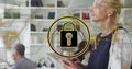 Image of security padlock icon against caucasian woman using digital tablet at office Royalty Free Stock Photo