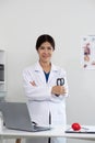 The image of a senior doctor smiling happily Dressed in a white robe, standing with arms crossed, holding a stethoscope. Royalty Free Stock Photo