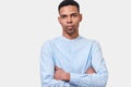 Image of serious African American young man stands with arms crossed, isolated on white background Royalty Free Stock Photo