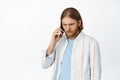 Image of serious blond guy receive concerning phone call, man talking on mobile cellular gadget, frowning, standing Royalty Free Stock Photo