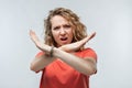 Image of serious blonde girl making X sign with crossed hands. Studio shot, white background. Human emotions concept Royalty Free Stock Photo