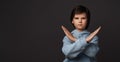 Image of serious boy in casual clothes making X sign with crossed hands, gesturing stop. Mock up copy space Royalty Free Stock Photo