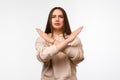 Image of serious woman 20s with long chestnut hair frowning and doing rejection gesture with hands Royalty Free Stock Photo