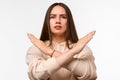 Image of serious woman 20s with long chestnut hair frowning and doing rejection gesture with hands Royalty Free Stock Photo
