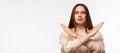 Image of serious woman 20s with long chestnut hair frowning and doing rejection gesture with hands. Copy space Royalty Free Stock Photo