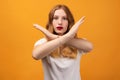 Image of serious woman 20s with wavy redhead, making X sign with crossed hands, gesturing stop Royalty Free Stock Photo