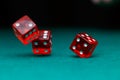 Image of several red dice falling on green table on black background Royalty Free Stock Photo