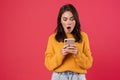 Image of shocked brunette girl posing and using mobile phone