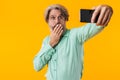 Shocked grey-haired man take a selfie by mobile phone