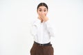 Image of shocked saleswoman, covers her mouth with hands and looks astonished at camera, white background Royalty Free Stock Photo