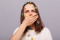 Image of shocked scared woman covered with funny stickers posing isolated over gray background, sees something frighten, covering Royalty Free Stock Photo