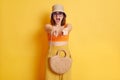 Image of shocked surprised young woman wearing swimsuit, shorts and panama, pointing fingers to camera, choosing you, posing