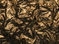 Shiny Crinkled Gold Foil Texture Background with Dynamic Shadows and Highlights. Royalty Free Stock Photo