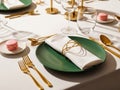Elegant dining table setting with green plate and gold utensils isolated on white background Royalty Free Stock Photo