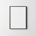 A simple black framed blank picture hangs on a plain white wall creating a minimalist and modern display space for art or photos Royalty Free Stock Photo
