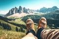 Feet of a Sitting Man on Top of a Grassy Mountain With a Beautiful View of a Rocky Mountain - Generative AI