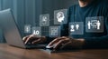 Man using laptop with digital icons representing online education, e-learning, and knowledge transfer for modern learning. Royalty Free Stock Photo