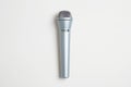 A sleek silver condenser microphone stands vertically against a stark white background Royalty Free Stock Photo