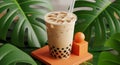 Bubble Tea with Ice Cubes and Orange Ball on Green Leaves Background Royalty Free Stock Photo