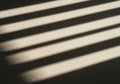 Soft shadows of parallel lines cast on a textured surface under sunlight Royalty Free Stock Photo